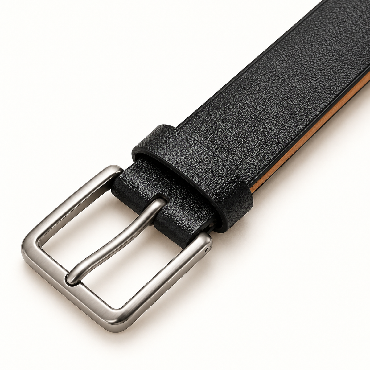Close-up of the plain rectangular silver-tone pin buckle, matching black keeper and adjoining lightly textured black leather strap on a warm-white background.