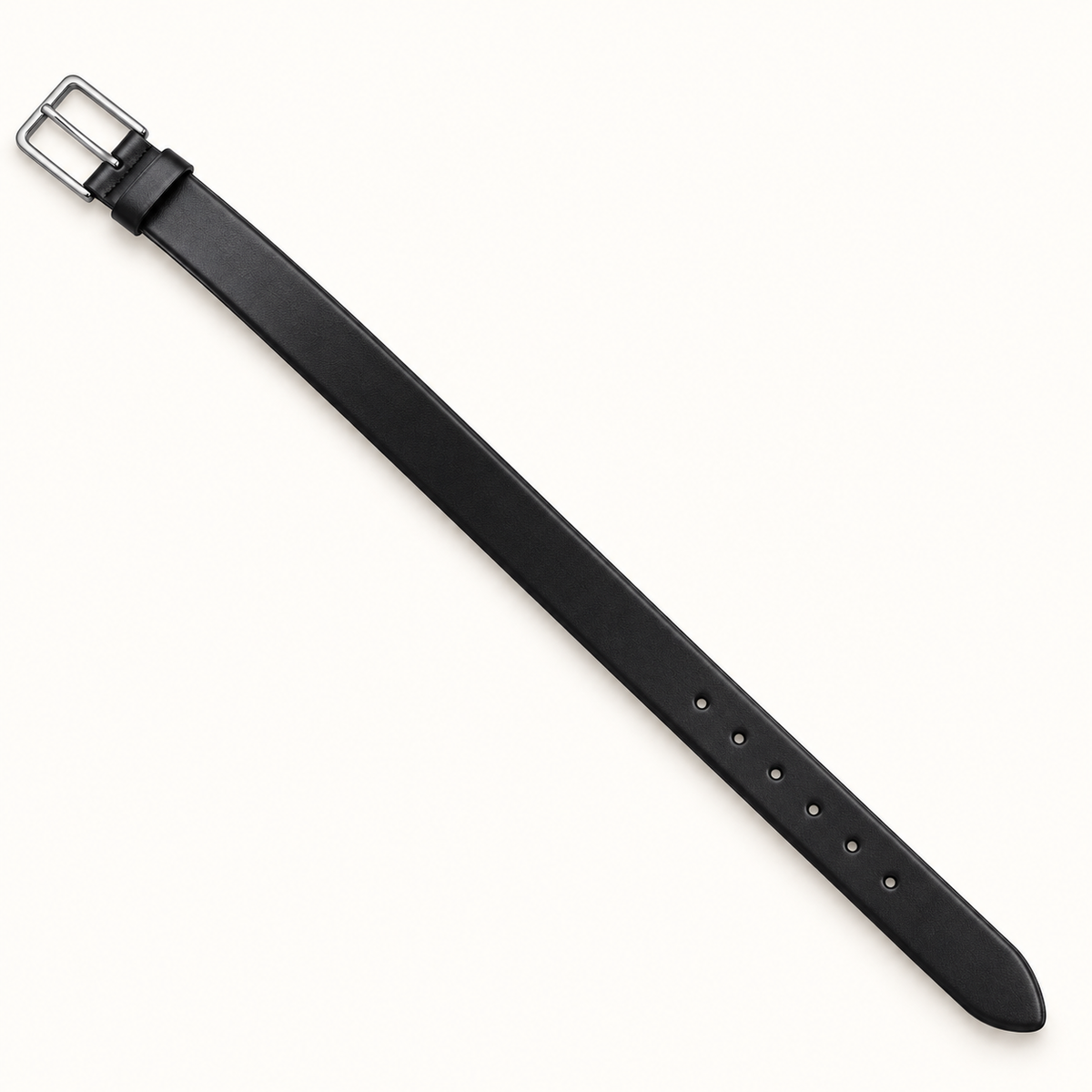 Full-length diagonal view of a slim black leather belt with a smooth finish, plain rectangular silver-tone pin buckle, matching keeper, round adjustment holes and rounded tip on a warm-white background.