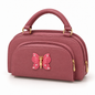 Pink top-handle handbag in three-quarter view with a fine textured surface, curved front zip pocket, butterfly ornament and gold-tone hardware.