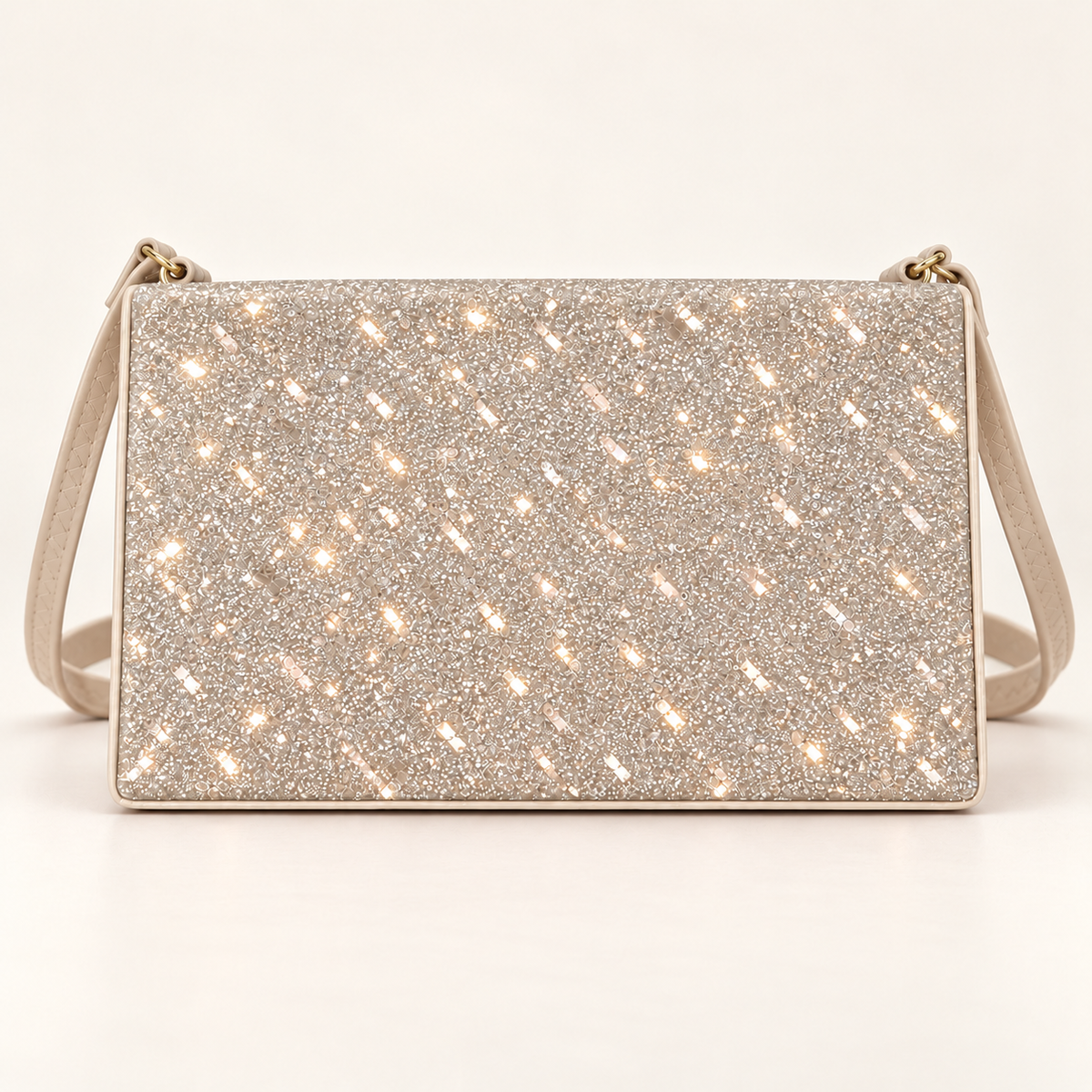Front view of a champagne rectangular women's sling bag with a sparkling glitter panel, matching shoulder strap and gold-tone strap rings on a plain light background