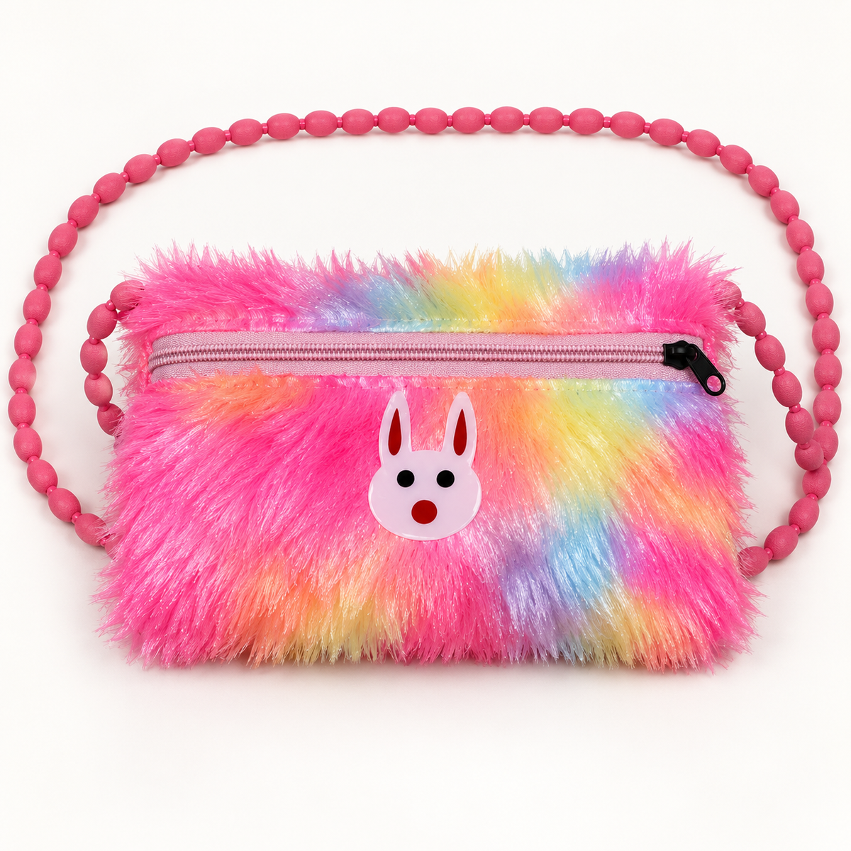 Straight-on view of a pink rainbow fuzzy shoulder pouch with yellow, blue and purple patches, a pale pink rabbit ornament, closed zipper and beaded strap.