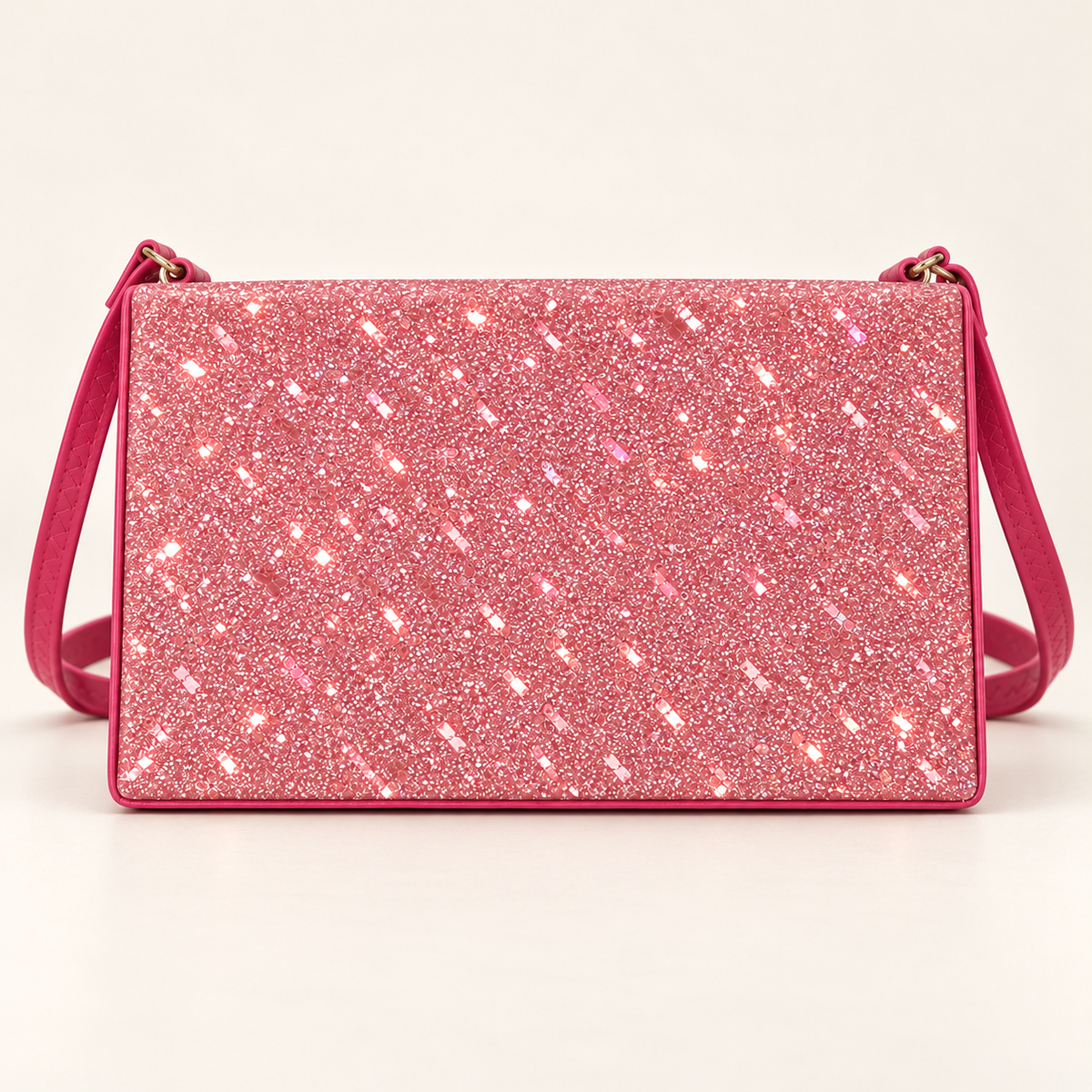 Front view of a hot pink rectangular women's sling bag with a sparkling glitter panel, matching shoulder strap and gold-tone strap rings on a plain light background